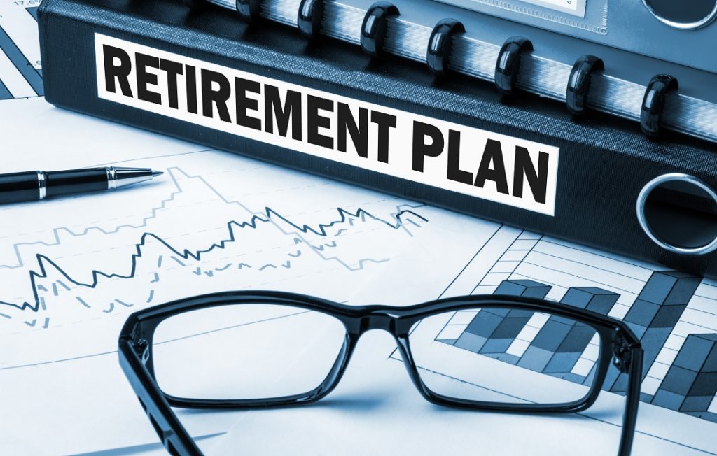 Binder with the label of "Retirement Plan" laying on top of a graph